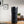 Electric Coffee Travel Mug juodas V2 - 355ml ant stalo su skaitmeniniu temperatūros rodmeniu modernioje vidaus aplinkoje.